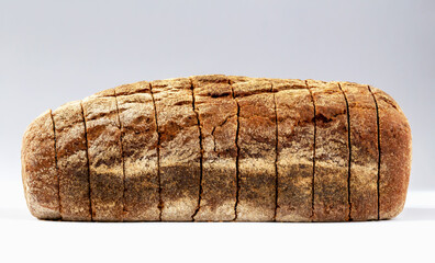 Loaf of freshly baked dark sliced bread on white background
