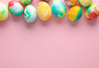 Fototapeta na wymiar Multicolored Easter eggs on a pink background. Copy space