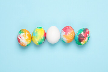 Multi-colored and white Easter eggs on a blue background