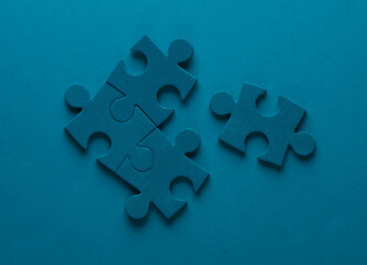 Blue jigsaw puzzle particles on blue background. Business concept