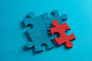 Blue and red jigsaw puzzle pieces on blue background. Business concept