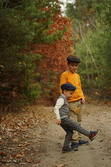 Brothers in retro clothes walk through the autumn forest.