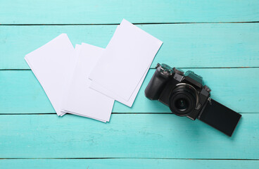 Modern camera and blank photo mockups on blue wooden boards. Top view