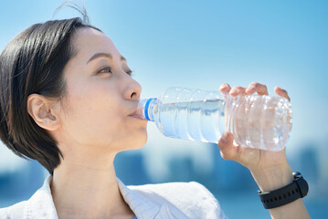 ペットボトルに入った水を飲む女性