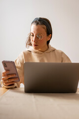 girl working at home. Girl using mobile smiling while working	