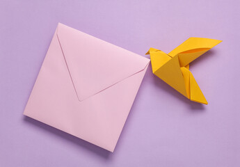 Origami dove holding purple envelope on a pastel background. Creative layout