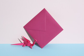 Purple origami dragon with envelope on pastel background. Minimal, creative layout