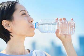ペットボトルに入った水を飲む女性