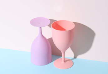 Creative layout with plastic colored glasses or goblets on a pastel background with a shadow. minimalism. Conceptual party concept