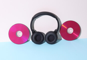 Creative layout. Pink CD disks with stereo headphones on a pastel background. Music concept