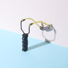 Slingshot on pastel background. Creative layout. Minimalism