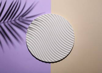 Round wavy platform on a pastel background with palm leaf shadow. Creative showcase.Top view