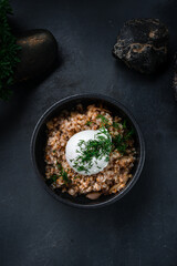 Boiled buckwheat porridge with fried onions, poached egg and herbs.