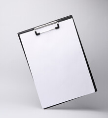 Clipboard with a white sheet of paper levitating on a gray background with shadow. Creative mockup. Business concept