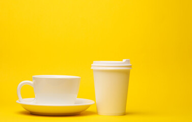 White cardboard and ceramic cups on yellow background. Template for design