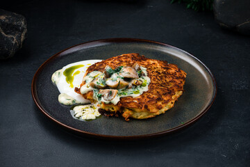 Fried potato pancakes with mushrooms, onions, greens and sauce.