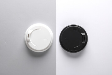 White and black plastic disposable lids for cup on gray white background. Mockup, template for design