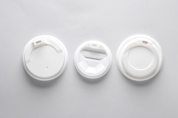White plastic disposable lids for cup on gray white background. Mockup, template for design