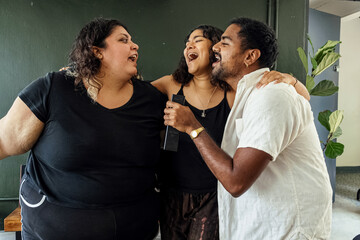 Friends dancing and singing together at home on a weekend