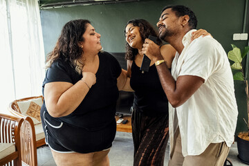 Friends dancing and singing together at home on a weekend