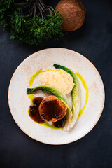 Chicken cutlet with mashed potatoes, greens and sauce in plate.