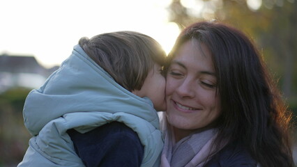 Happy mother and child relationship. Small son kissing mom in cheek. Real life moterhood lifestyle. loving caring parenting motherhood lifestyle