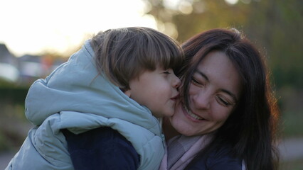 Happy mother and child relationship. Small son kissing mom in cheek. Real life moterhood lifestyle. loving caring parenting motherhood lifestyle