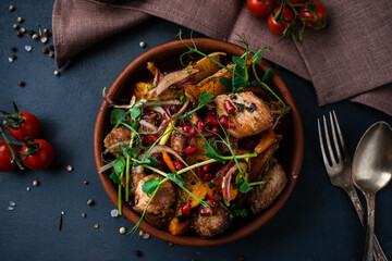 Fried pork pieces with potato wedges, onions, sweet peppers, tomatoes, pomegranate seeds and herbs...