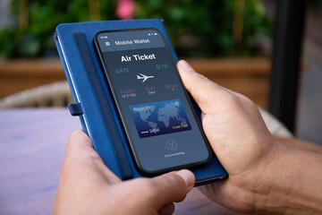 Male hand hold phone with airplane ticket application airlines airport