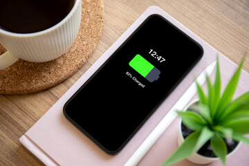 phone with charged battery background wooden table in the office