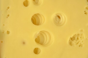 A pile of sliced cheese with big holes, closeup