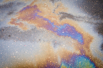 Background texture of oil spill on dark asphalt, parking lot.