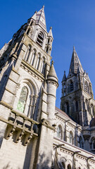 Obraz premium The tall Gothic spire of an Anglican church in Cork, Ireland. Neo-Gothic architecture. Cathedral Church of St Fin Barre, Cork - One of Ireland’s Iconic Buildings.