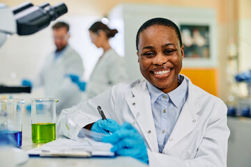 Happy African American female scientist in lab looking at camera.