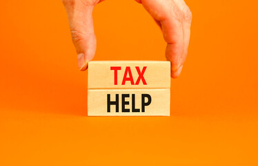 Tax help symbol. Concept words Tax help on wooden blocks on a beautiful orange table orange...