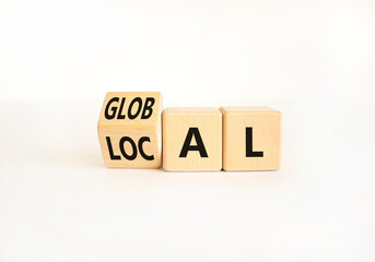 Local or global symbol. Businessman turns wooden cubes and changes the word Local to Global. Beautiful white table white background. Business and local or global concept. Copy space.