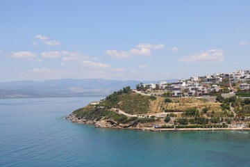 Fototapeta na wymiar Turquoise water and green rocky shores of the Aegean Sea, Turkiye, May 2023.