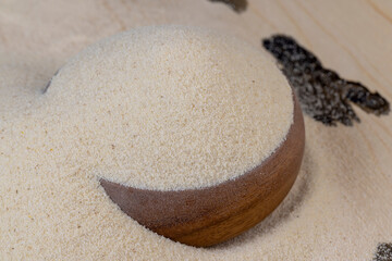 Fototapeta na wymiar Semolina poured into a round wooden bowl ready for cooking