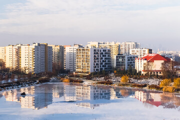 Cityscape with buildings mirroring in the lake.