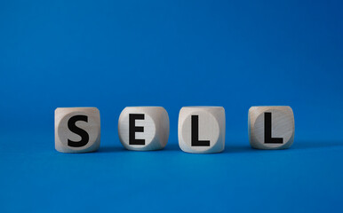 Sell symbol. Concept word Sell on wooden cubes. Beautiful blue background. Business and Sell concept. Copy space.
