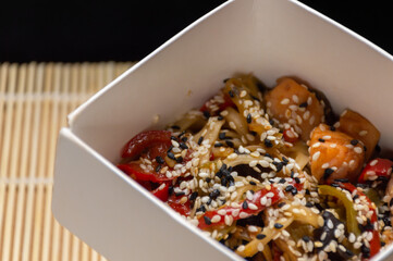 Chinese noodles with salmon, vegetables and sesame seeds