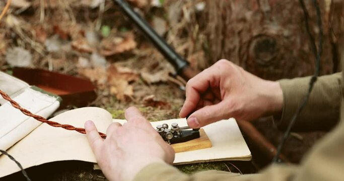 Russian Soviet Infantry Red Army Soldier In World War II using Russian Soviet Portable Radio Transceiver In Trench Entrenchment In Spring Autumn Forest. 4K. Headphones And Telegraph Key. Close Up