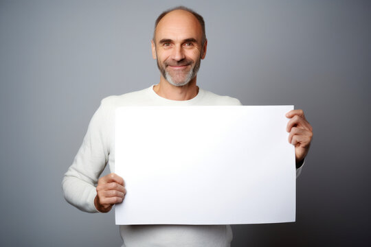 Portrait of a happy mature man holding a blank sheet of paper