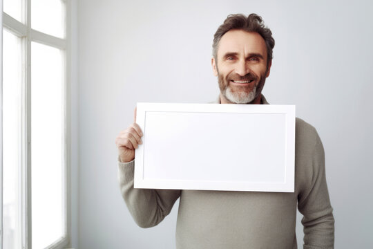 Handsome middle-aged man holding a whiteboard in his hands