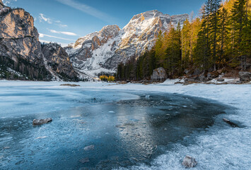 panorama sul lago di braies ancora ghiacciato all'alba, con la croda del becco sullo sfondo