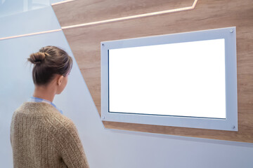 Woman looking at blank digital interactive white display wall at exhibition, museum with futuristic...