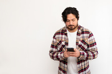 Latin person portrait typing in his cell phone in white background with copy space