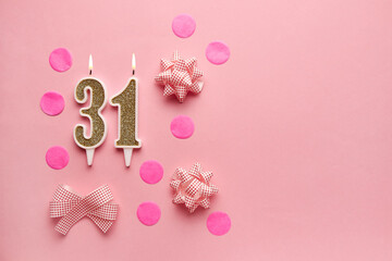 Number 31 on pastel pink background with festive decor. Happy birthday candles. The concept of celebrating a birthday, anniversary, important date, holiday. Copy space. Banner