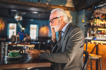 Senior man businessman business owner use digital tablet sit at cafe