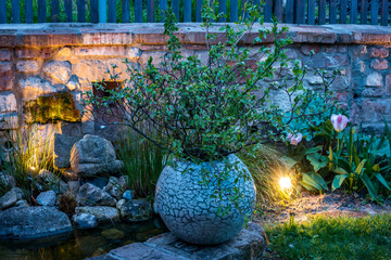 Evening lights in a rustic garden with willow twigs in a vase